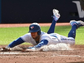 Blue Jays right fielder George Springer slides across home plate as he scores a run against the Braves in the seventh inning at Rogers Centre in Toronto, Saturday, May 13, 2023.