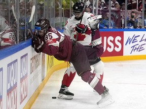 Canada's Joe Veleno knocks down Latvia's Dans Locmelis during the world championship in Riga on May 12, 2023.