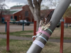 Feathers are placed outside Crawford Plain School in Edmonton on Saturday, May 6, 2023. A mother and child who were stabbed to death outside the school earlier this month.