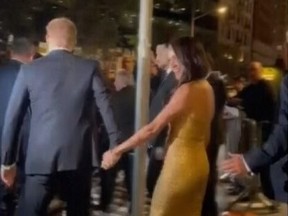 In this image from video, Prince Harry and his wife Meghan exit Manhattan's Ziegfeld Ballroom on Tuesday, May 16, 2023 in New York. The couple's office says the pair and Meghan's mother were followed by vehicles after leaving a charity event on Tuesday.