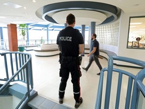 Edmonton Police Service school resource officer watches the halls at St. Joseph High School in Edmonton, May 5, 2022.