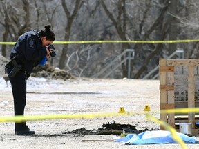 A forensics officer takes photographs at the scene of a fatal fire police are calling suspicious in a warehouse district at the northern end of Gomez Street, near MacDonald Avenue in the south Point Douglas area of Winnipeg on Thursday, April 27, 2023. A 23-year-old Winnipeg man has been charged with second-degree murder after being arrested in connection of the death.