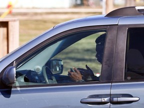 A person uses their cellphone while driving