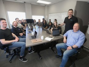 Dave Berekowits, Chief Technical Officer at QDoc (seated on the far right) and Dr. Norm Silver, co-founder and Chief Executive Officer at QDoc (standing beside Berkowits) with their software development team at QDoc headquarters in Winnipeg. Chris Procaylo/Winnipeg Sun