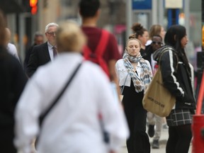 People walking on a sidewalk in downtown Winnipeg.