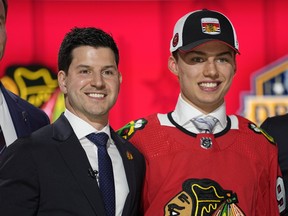 Chicago Blackhawks general manager Kyle Davidson, left, poses with first round draft pick Connor Bedard.
