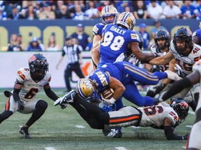 Bombers running back Brady Oliveira tries to fight through the line against the B.C. Lions.