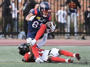 Montreal Alouettes' Austin Mack (81) is tackled by Ottawa Redblacks' Abdul Kanneh during first half CFL football action in Montreal, Saturday, June 10, 2023.