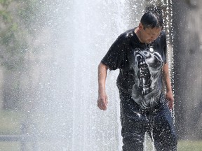 A person cools off in a public fountain