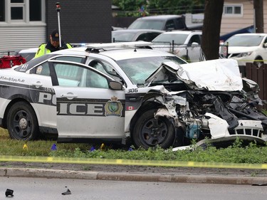 A police cruiser with airbags deployed and a trauma bag on top of the trunk sits in a median on Main Street between Kilbride and Belmont avenues as officers investigate a crash in Winnipeg on Wed., June 7, 2023.  KEVIN KING/Winnipeg Sun