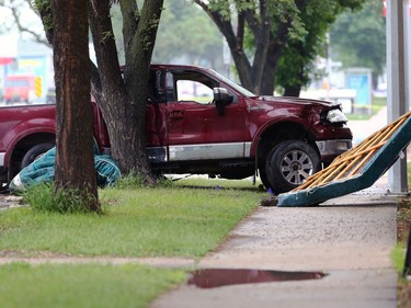 A truck involved in a crash with a police cruiser sits up against a tree on a Main Street boulevard between Kilbride and Belmont avenues in Winnipeg on Wed., June 7, 2023.  KEVIN KING/Winnipeg Sun