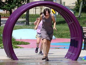 Woman runs through a sprinkler