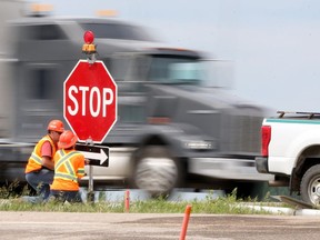 Workers replace a stop sign