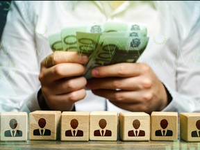 Businessman counting euro money over employee figures. Calculation of the company's profit. Payment personnel work, cost optimization. Accounting and budgeting. Payday. Investments and lending.