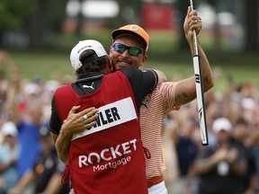 Rickie Fowler and his caddie, Ricky Romano, celebrate on the 18th green after winning the Rocket Mortgage Classic at Detroit Golf Club on July 2, 2023 in Detroit.