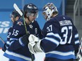 Winnipeg Jets centre Mark Scheifele (left) and goaltender Connor Hellebuyck