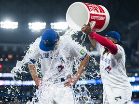 Jordan Romano of the Toronto Blue Jays is doused in water by teammate Vladimir Guerrero Jr.