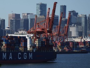 Cranes sit idle as a container ship is docked at port during a work stoppage in Vancouver on Wednesday, July 19, 2023.