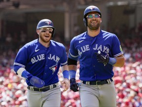The Toronto Blue Jays' Kevin Kiermaier, right, jogs to the dugout with Danny Jansen after hitting a two-run home run against the Cincinnati Reds in the second inning of their game in Cincinnati on Sunday, Aug. 20, 2023.