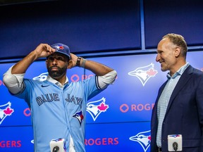 Jose Bautista receives a Toronto Blue Jays jersey from Blue Jays president and CEO Mark Shapiro during a press conference at the Rogers Centre in Toronto in Toronto, Ont. on Friday August 11, 2023. Bautista signed a one-day contract this afternoon to officially retire as a member of the Toronto Blue Jays. Ernest Doroszuk/Toronto Sun/Postmedia