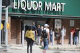 People line up near a Liquor Mart, in Winnipeg on Thursday, August 10, 2023