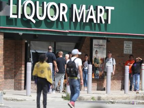 People line up near a Liquor Mart, in Winnipeg on Thursday, August 10, 2023
