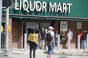 People line up near a Liquor Mart, in Winnipeg on Thursday, August 10, 2023