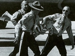 RCMP officers haul off 17-year-old Bruce Decker who managed to get onto the tarmac at the Winnipeg International Airport after the Beatles made a brief refueling stopover in 1964.