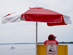 A lifeguard works at Brittany Beach on the Ottawa River in Ottawa on Friday, June 24, 2022. Lifesaving Society Ontario says water floaties have become a large problem this summer, urging people to leave them out of open bodies of water.