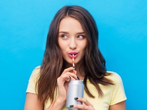 Young woman drinking through a straw