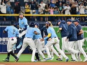 Rays batter Josh Lowe (second left) celebrates with teammates after hitting a walk-off RBI single in the ninth inning to defeat the Blue Jays 7-6 at Tropicana Field in St. Petersburg, Fla., Saturday, Sept. 23, 2023.