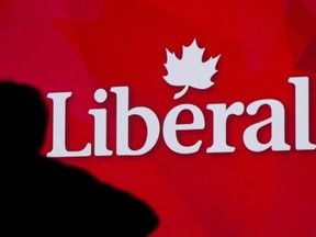 A Liberal Party of Canada logo is shown on a giant screen as a technician looks on during day one of the party's biennial convention in Montreal, Thusday, February 20, 2014.