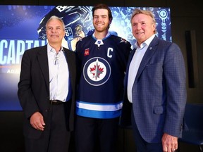 Winnipeg Jets newest captain Adam Lowry (centre) between general manager Kevin Cheveldayoff (left) and head coach Rick Bowness at Canada Life Centre on Tuesday. Kevin King/Winnipeg Sun