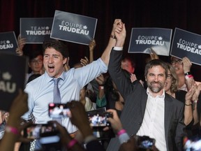 Canadian Prime Minister Justin Trudeau, left, raises the hand of Steven Guilbeault during an event to launch his candidacy for the Liberal party of Canada in Montreal, Wednesday, July 10, 2019.