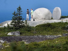 Visitors look out to the ocean from the Swissair Flight 111 memorial at Whalesback near Peggy's Cove, N.S. on Thursday, Aug. 30, 2018.