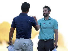 Tom Kim of South Korea shakes hands with Canadian Adam Hadwin after their round on the 18th green during the final round of the Shriners Children's Open at TPC Summerlin on Sunday, Oct. 15, 2023, in Las Vegas.