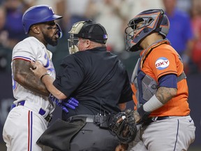 Adolis Garcia of the Texas Rangers argues with Martin Maldonado of the Houston Astros after being hit by a pitch at Globe Life Field on October 20, 2023 in Arlington, Texas.