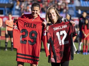 Canada forward Christine Sinclair, left, exchanges jerseys with hockey player Marie-Philip Poulin prior to a friendly international soccer match against Brazil, Saturday Oct. 28, 2023 in Montreal.