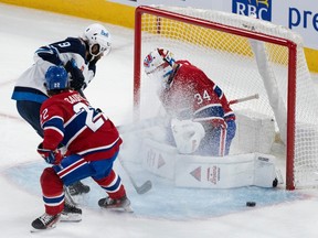 Montreal Canadiens goaltender Jake Allen (34) makes a save against Winnipeg Jets' Alex Iafallo (9)