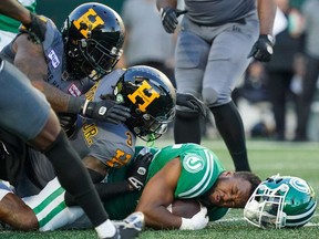 Saskatchewan Roughriders running back Jamal Morrow (25) is tackled by Hamilton Tiger-Cats defenders during the first half of CFL football action at Mosaic Stadium in Regina, on Saturday, Oct. 7, 2023.