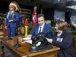 The Manitoba government is looking at Jan. 1 for the start of a fuel-tax holiday to help motorists with inflation. Manitoba Premier Wab Kinew looks on as Adrien Sala, Minister of Finance, is sworn-in by Lt. Gov. Anita Neville at a swearing-in ceremony in Winnipeg, Wednesday, Oct. 18, 2023.