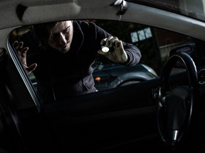 A car thief looks into a vehicle