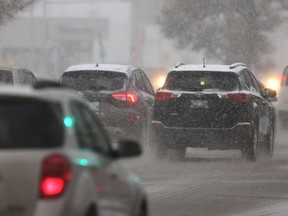 Traffic on wet roads during an early morning snowfall in Winnipeg.