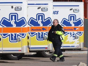A paramedic walks past parked ambulances