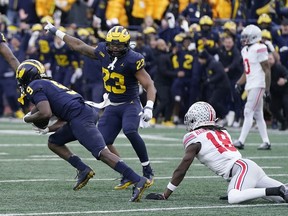 Michigan Wolverines defensive back Rod Moore intercepts a pass intended for Ohio State Buckeyes wide receiver Marvin Harrison Jr. at Michigan Stadium in Ann Arbor on Saturday, Nov. 25, 2023.