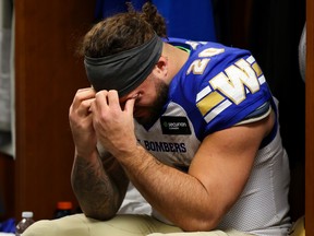 O running back do Winnipeg Blue Bombers, Brady Oliveira (20), olha para baixo no vestiário depois de perder para o Montreal Alouettes na 110ª CFL Grey Cup em Hamilton, no domingo.