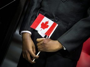 An immigrant holds a Canadian flag