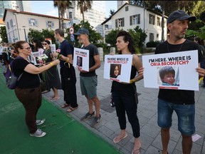 People carry placards bearing pictures of missing persons