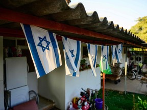 Israeli flags hang at an empty house in the evacuated Kibbutz Dan