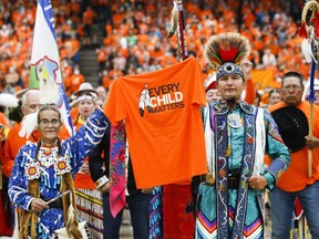 Sherry Starr and Wab Kinew lead the grand entrance at the second annual Orange Shirt Day Survivors Walk and Pow Wow in Winnipeg, Friday, Sept. 30, 2022. The Manitoba government has introduced a bill in the legislature to make Sept. 30 -- the National Day for Truth and Reconciliation -- a statutory holiday.